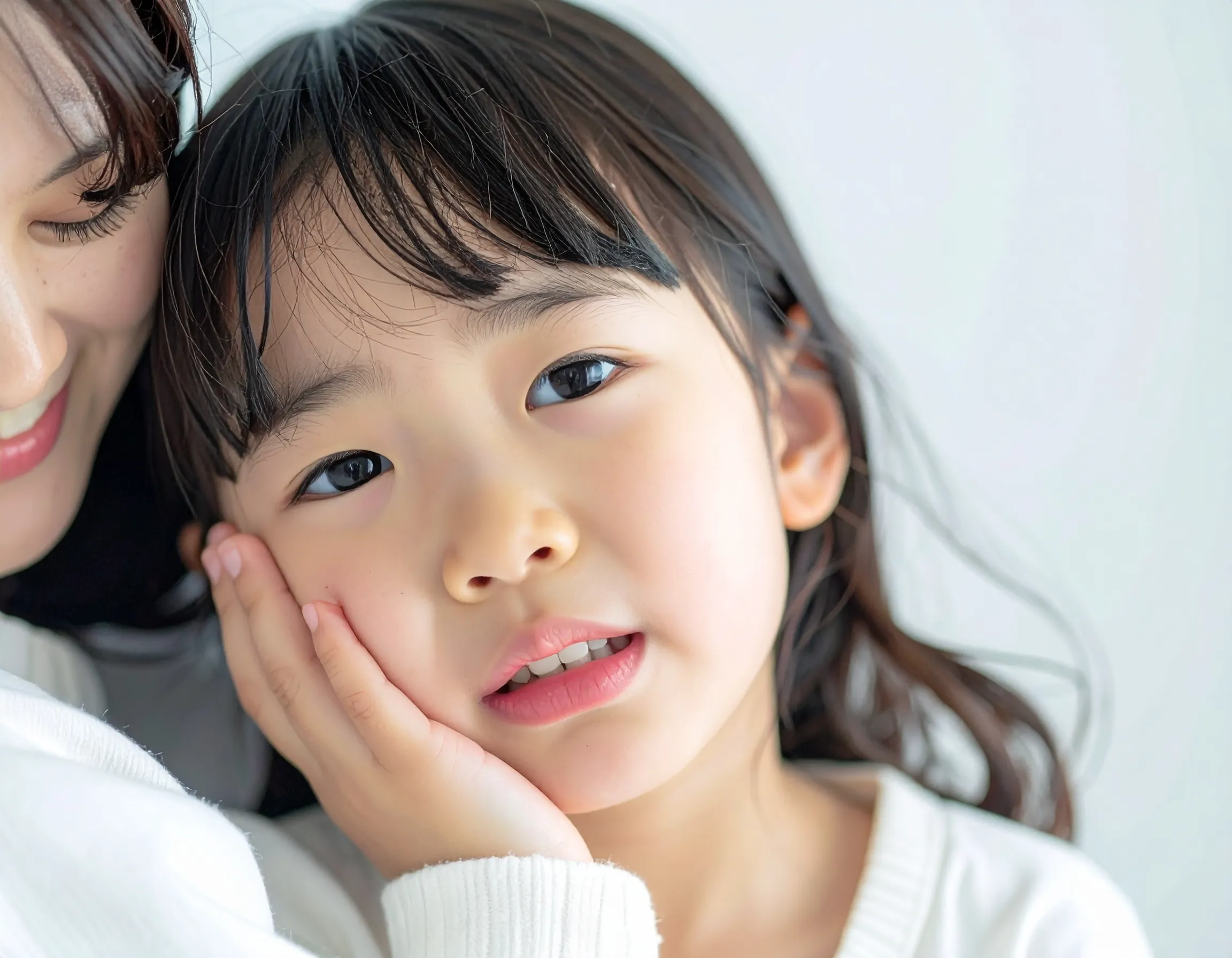 お母さんの膝の上で歯磨きをする男の子の画像