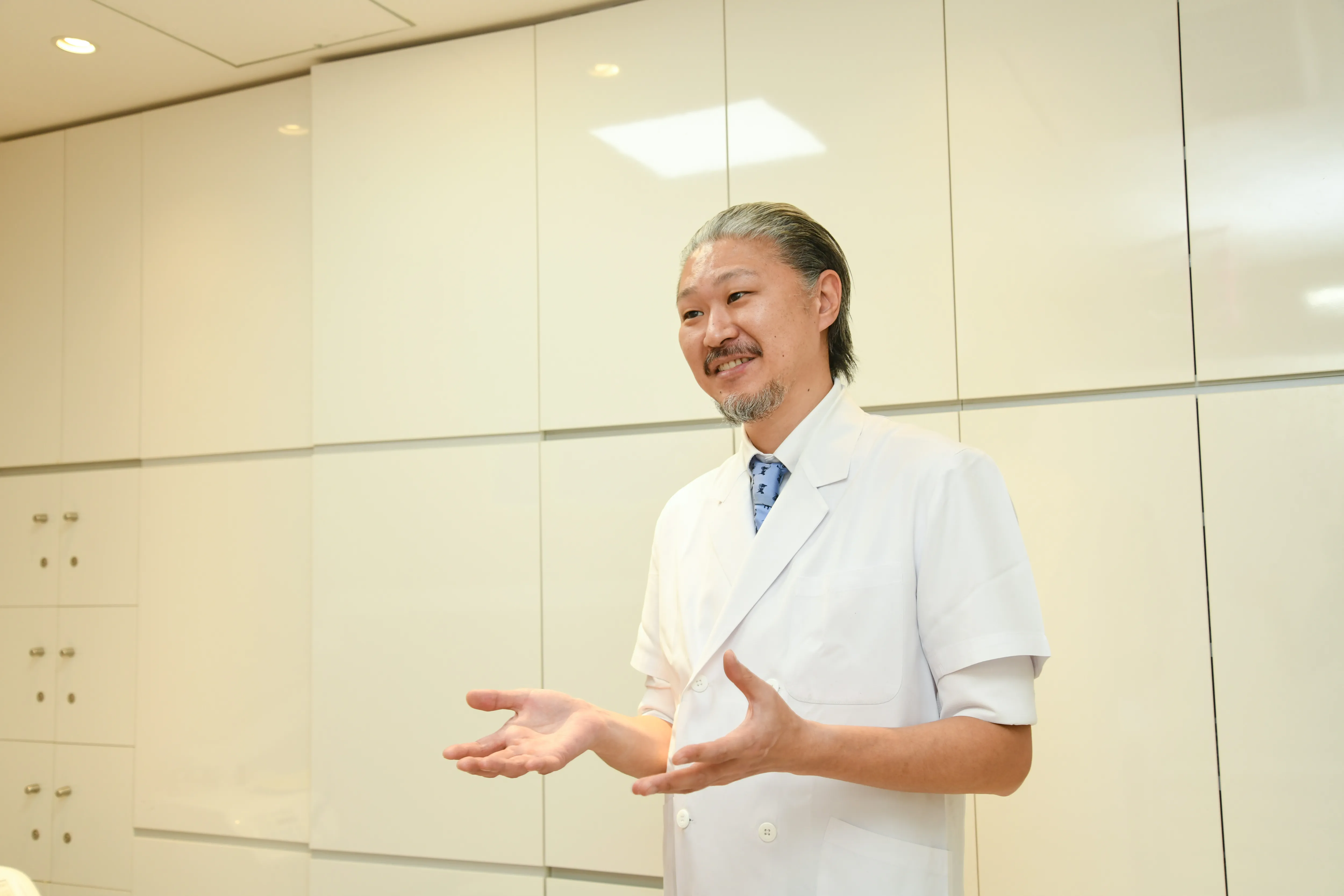 当院の親知らず抜歯における特徴を説明している男性